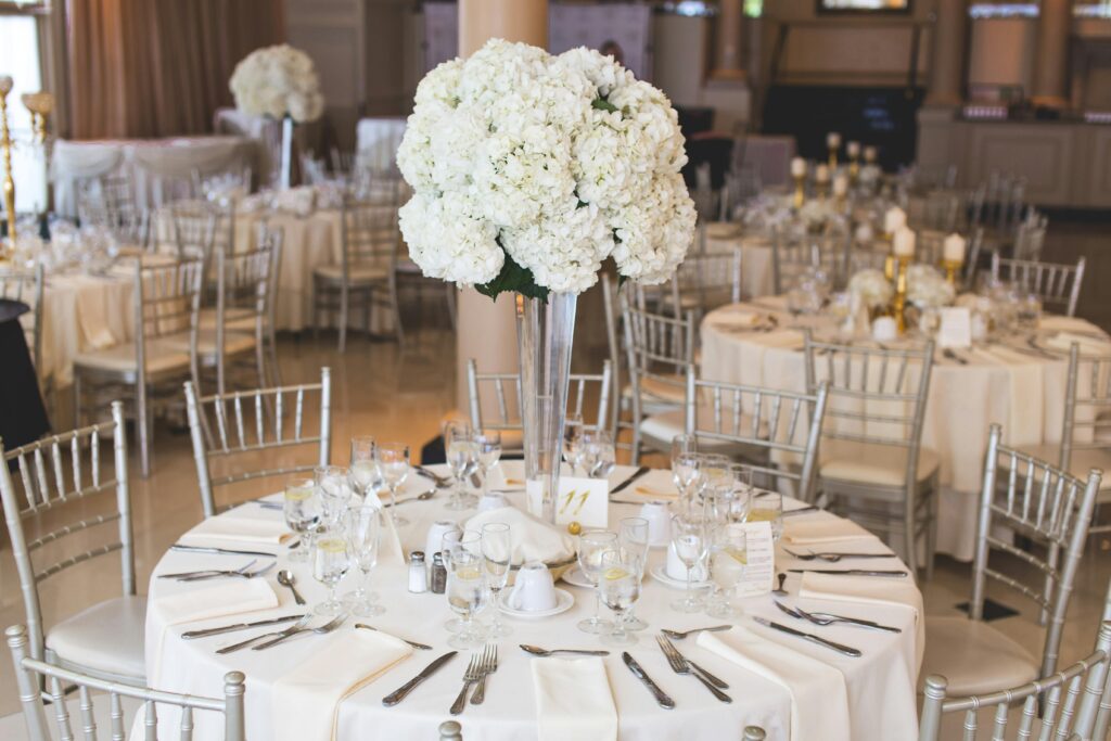 pexels-photo-2306281-2306281 Beautifully decorated wedding reception table with elegant floral centerpiece and silverware.